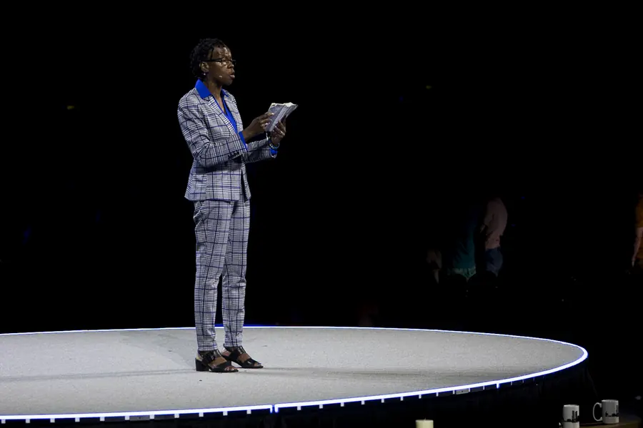 Speaker alone on a lit stage against a black backdrop