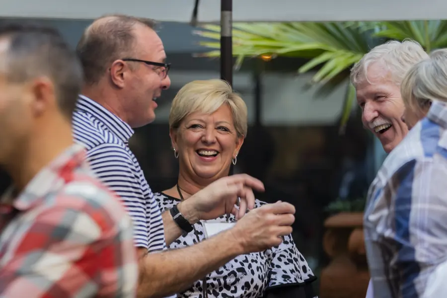 Guests laughing during an outdoor evening reception