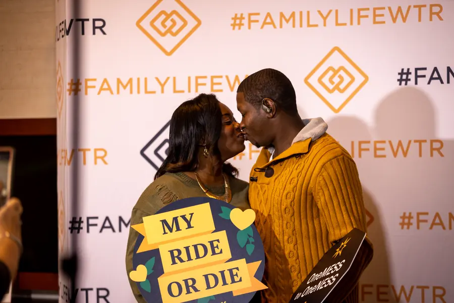 Couple photographed at an event step-and-repeat backdrop
