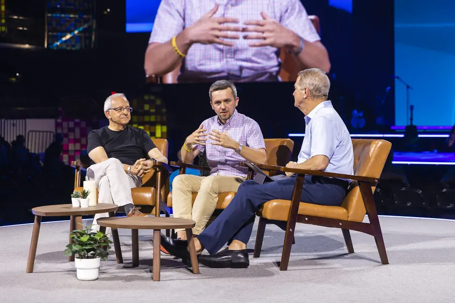 Three panelists in conversation on a conference stage