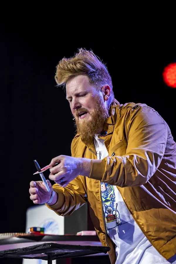 Performer mid-routine on stage under blue and red light