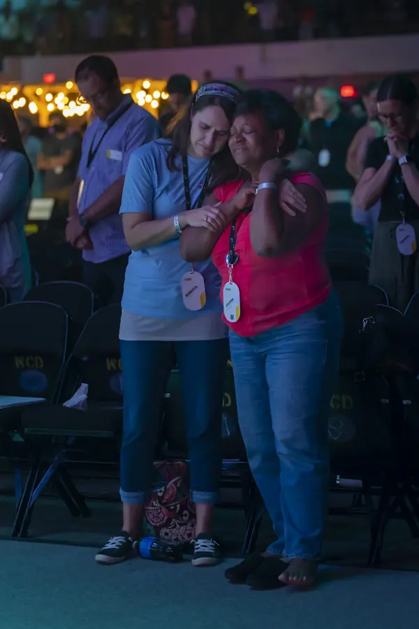 Two attendees embracing during an evening session