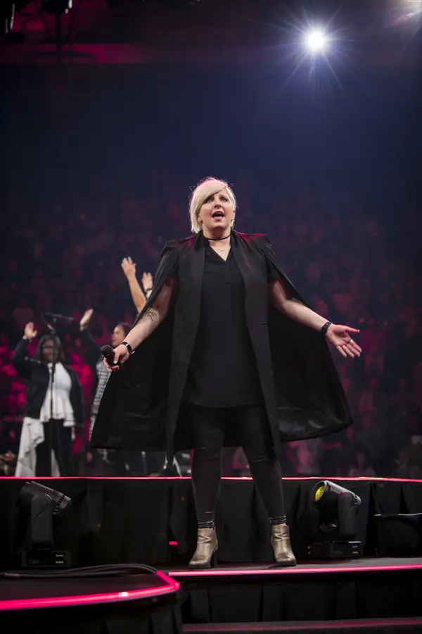Vocalist performing under a single overhead spotlight