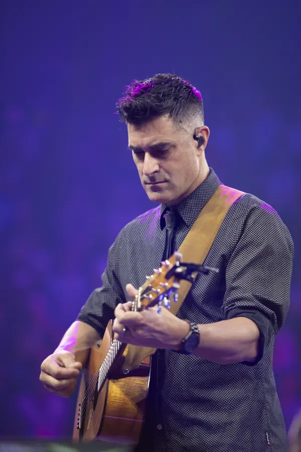 Guitarist performing in magenta stage light