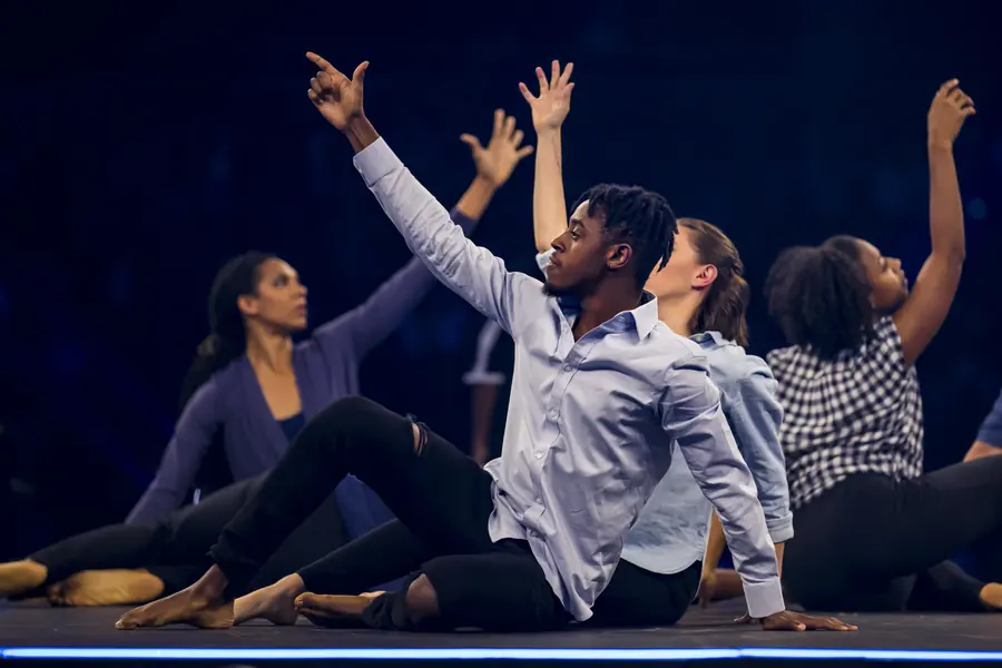 Dancers performing under blue stage light