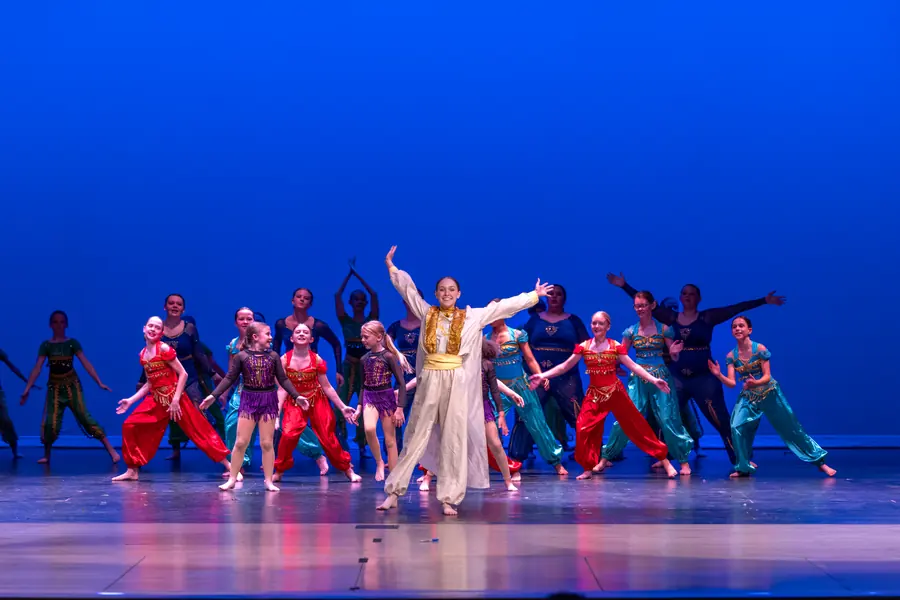 Full ensemble in colorful costume during a stage number