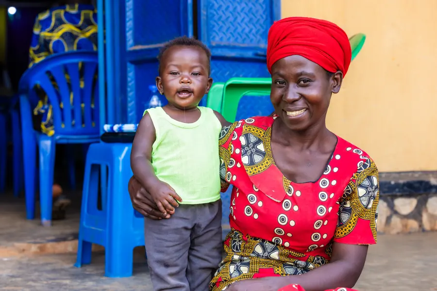 Mother in a red headwrap holding her toddler, Africa mission trip