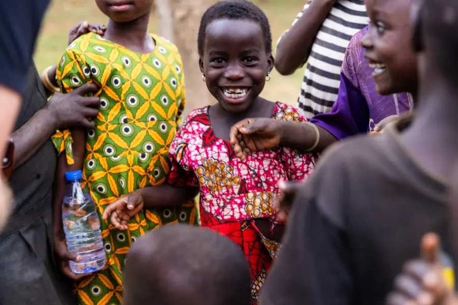 Girl in a yellow patterned dress at a village gathering