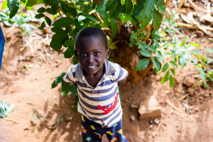 Child looking up at the camera on a village path