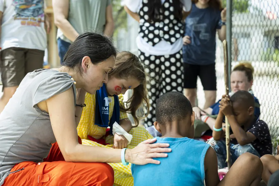 Team members praying over a child during a mission trip
