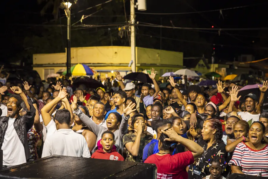Crowd with hands raised at an outdoor evening gathering