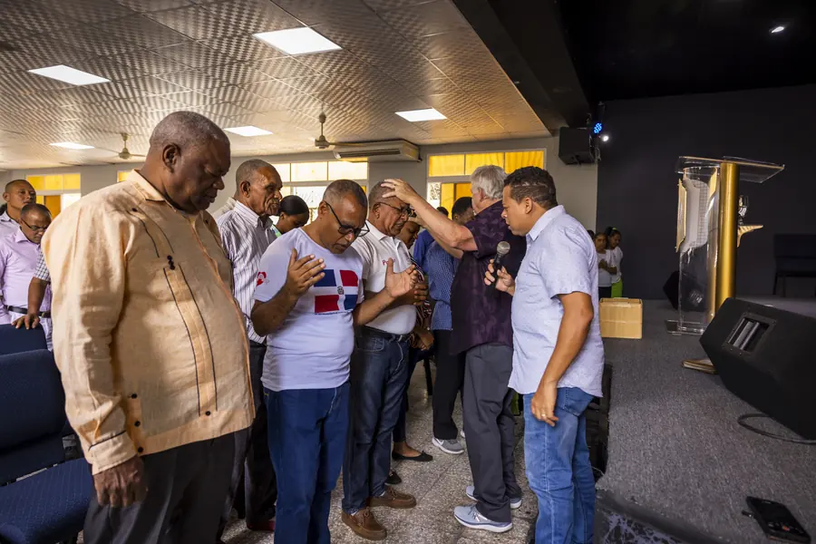 Group of men praying together in a circle