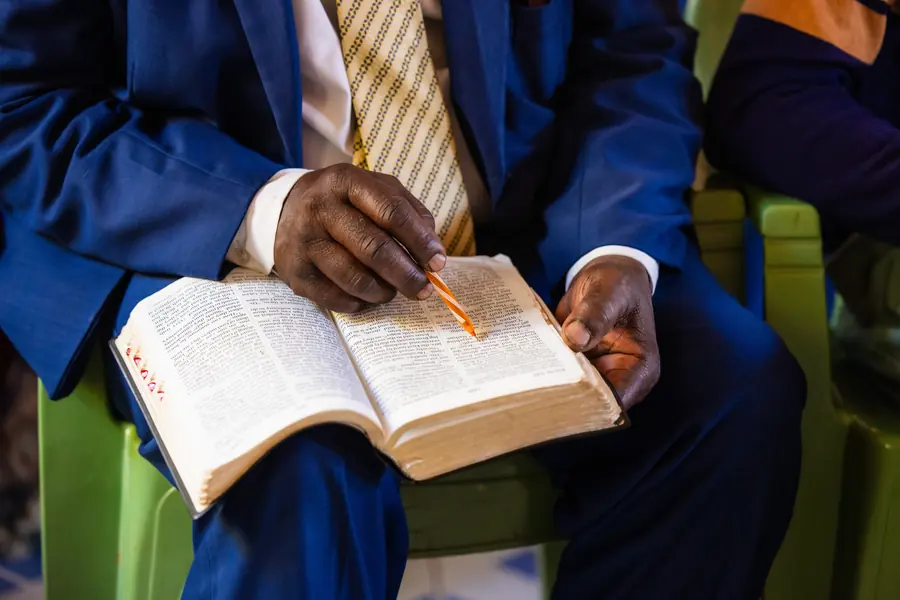 Close-up of hands taking notes during a ministry training session